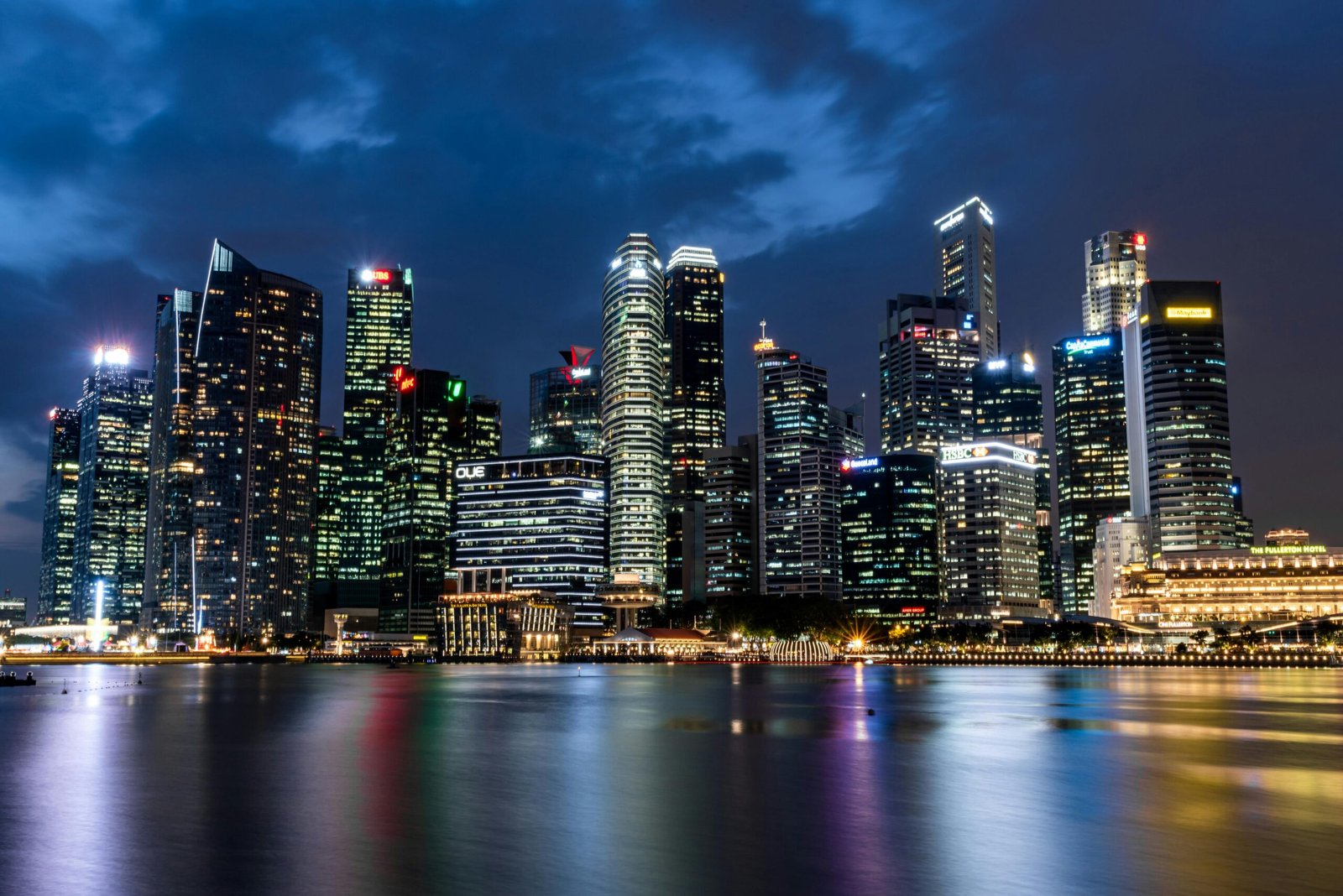 Illuminated Singapore skyline reflecting beautifully on waterfront at night.